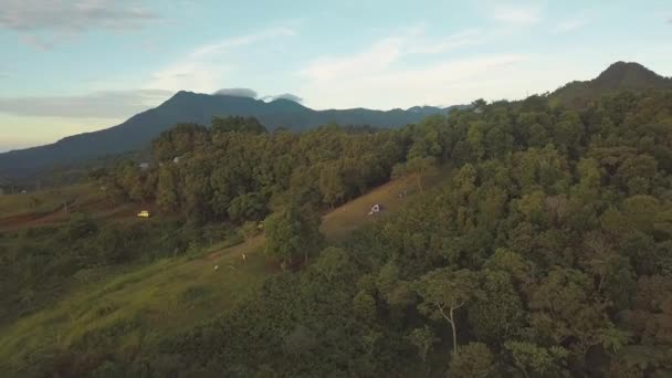 Εναέρια θέα ενός κάμπινγκ στους λόφους πλούσια σε δέντρα και βλάστηση. — Αρχείο Βίντεο