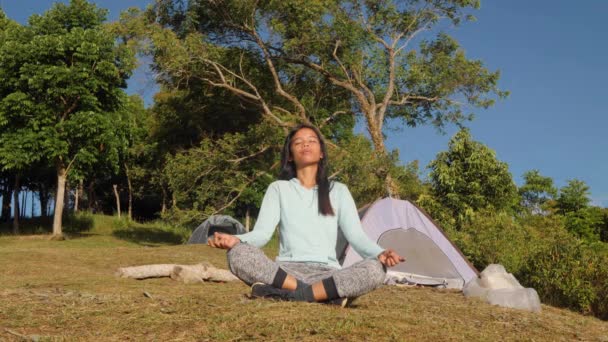 Mujer campista medita en las montañas al amanecer, en tiempo real . — Vídeo de stock