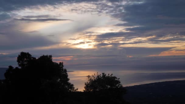 Timelapse схід сонця з барвистим небом і хмарами, океаном, деревами і горою . — стокове відео