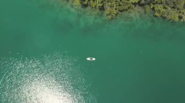 Güneşli bir günde bir kıyı lagün bir paddleboard seksi kız havadan çekim.