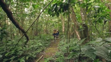 Mutlu bir adam, eski arkadaşıyla birlikte ormanda taş merdivenlerde yürüyor..
