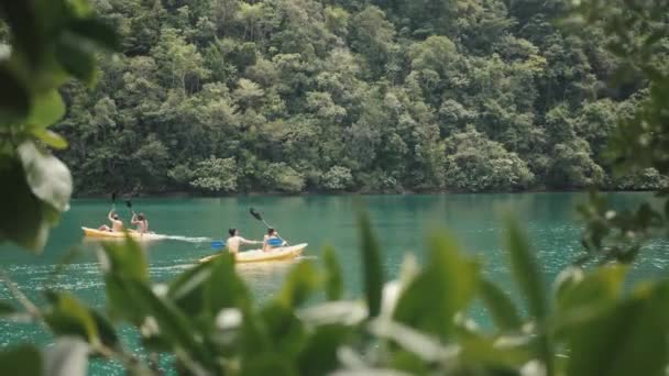 Zwei Paare genießen Kajakfahren in einer grünen Lagune auf den Philippinen — Stockvideo