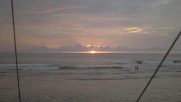 Tidig morgon pulserande soluppgång över havet och under moln i en surfingplats. — Stockvideo