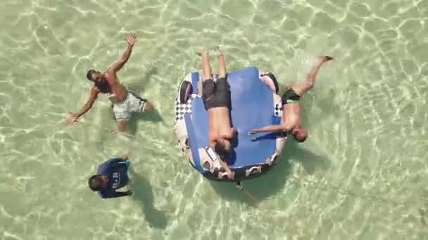 Filippijnen, Manjuyod, 18-05-2019: mannen vrienden op opblaasbare matras in de Oceaan. — Stockvideo