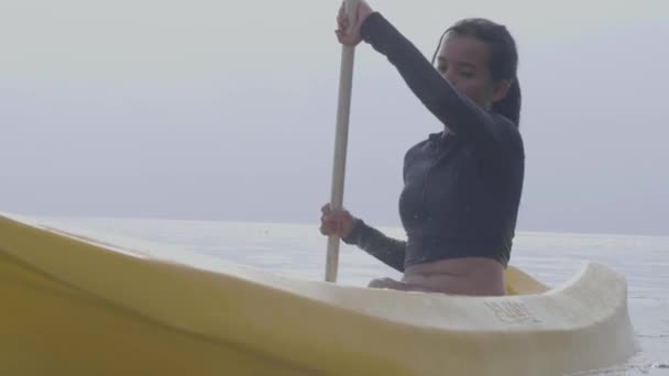 Detailní záběr: bezstarostná mladá žena pádlování a kajak v klidném oceánu. — Stock video