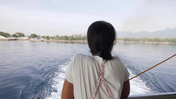 Mujer joven de pie en la cubierta del barco mirando el mar y el paisaje mientras navega . — Vídeos de Stock