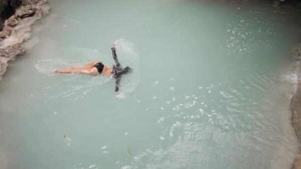 Schlanke Frau im Badeanzug genießt Schwimmen und Baden im Wasserfall — Stockvideo