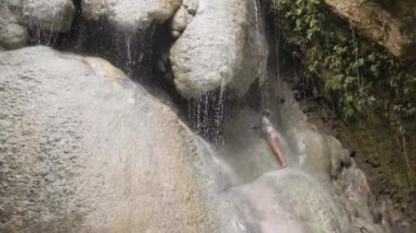 Yaz günü tropik şelale altında duş alan Asyalı kadın..