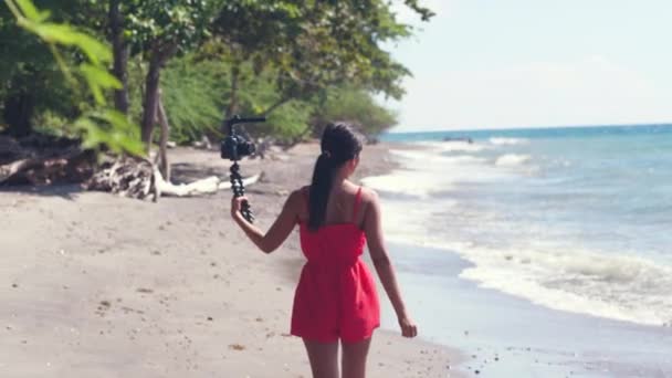 Millennial female vlogger filming travel and vacation vlog at the beach. — ストック動画