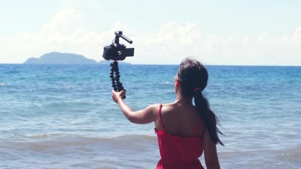 Joven influencer filmando su vlog de viaje en la playa en verano . — Vídeo de stock