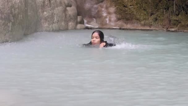 Young lady relaxing in tropical natural water swimming in rainforest waterfall. — Stock Video