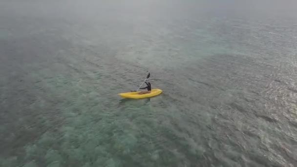 Punto de vista Drone: Un turista disfruta de kayak en el océano tranquilo en verano . — Vídeos de Stock