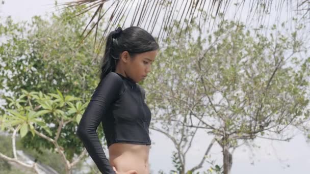Νεαρή γυναίκα vaction κάνει άσκηση μπροστά από τον ωκεανό σε ένα τροπικό θέρετρο. — Αρχείο Βίντεο