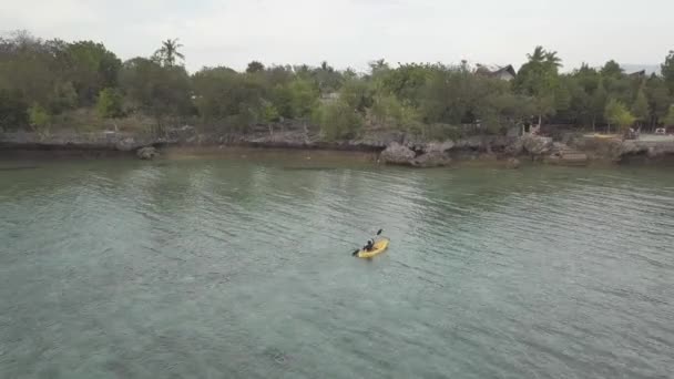 Imágenes de drones: kayak turístico femenino en el tranquilo mar en un resort tropical . — Vídeo de stock