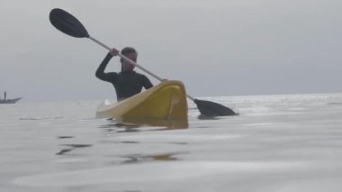 Güzel bir kadın sıcak bir yaz gününde okyanusta kayak yapıyor..