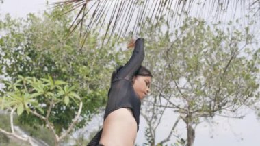 Doğayla iç içe egzersiz yapan odaklanmış Asyalı kadın..