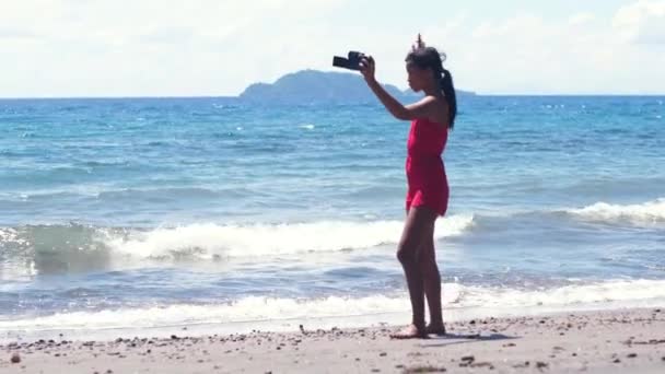 Una vlogger femenina filmando vídeo en la playa dejó caer su cámara en la arena . — Vídeos de Stock