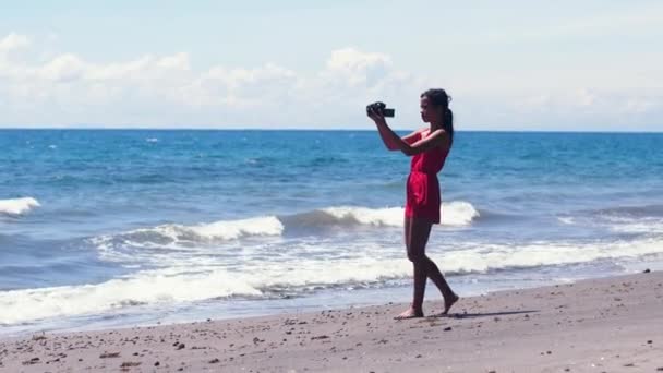 Videofilmerin. Videoaufzeichnung und Fotografieren am Strand im Urlaub — Stockvideo