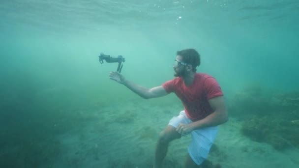 Divertente ragazzo cercando di lanciare un drone rotto sott'acqua . — Video Stock