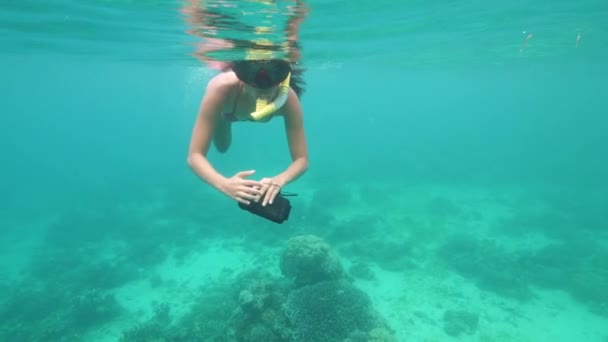 Egy nő búvármaszkban úszkál a kék óceánban korallokkal.. — Stock videók