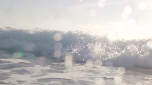 Gros plan d'une vague de mousse se brisant près du bord de la mer et se dirigeant vers la caméra 