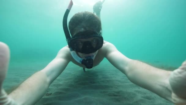 Selfie video de un hombre con máscara de snorkel nadando bajo el agua . — Vídeos de Stock