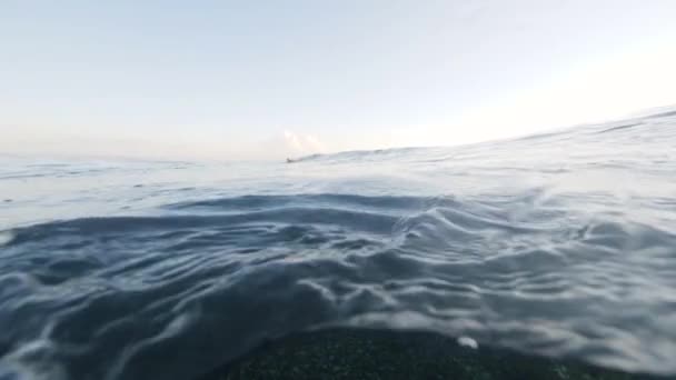 View of blue ocean waves above and underwater with view of ocean floor. — Stock Video