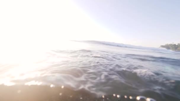 Ondas oceánicas por debajo y por encima de la superficie con vistas a una pequeña isla . — Vídeos de Stock