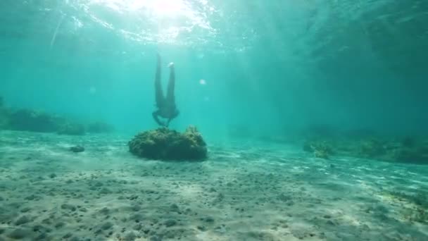 Menina sexy nadando sob a superfície dos oceanos com piso arenoso do oceano, e raios de sol — Vídeo de Stock