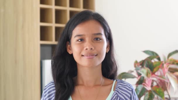 Sonriente joven mujer filipina pequeña cara mirando a la cámara posando en casa — Vídeos de Stock