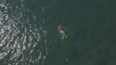 Mavi mayolu seksi erkek yaz günü okyanusta yüzmeyi seviyor.