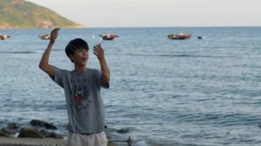 Cham Adası, Vietnam-06 18-2020: Bir adam deniz kenarında uçurtma ipini çekiyor