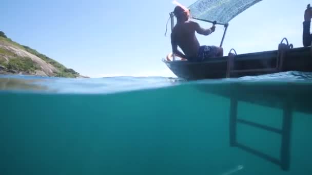 Mężczyzna w masce do nurkowania nagrywa selfie podczas spadania z łodzi — Wideo stockowe