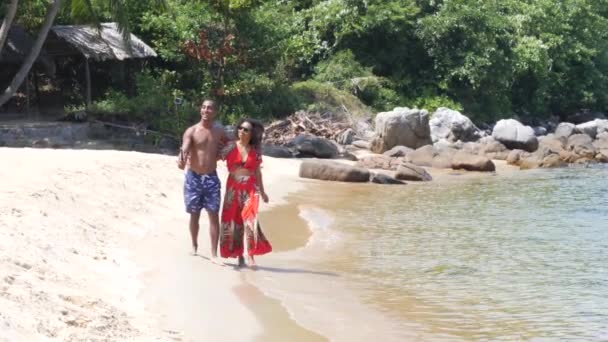 Carefree young couple vlogger filming video on camera while walking on the beach — Stock Video