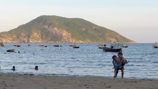 Cham Island, Vietnam-06 18 2020: Una madre cargando a su hijo en la playa. — Vídeo de stock