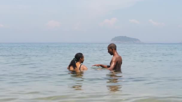 Junges Paar badet im Meer mit ruhigem Wasser auf tropischer Insel an einem Sommertag — Stockvideo