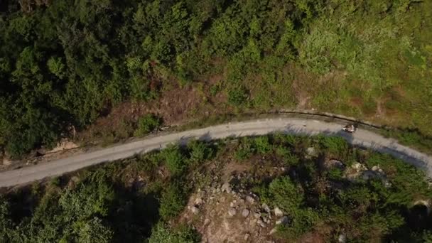 乘坐摩托车沿着山中弯弯曲曲的道路行驶的游客的空中景致. — 图库视频影像