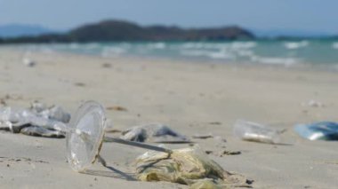 Plastik ve içme kamışı, deniz kıyısındaki kuma sürüklendi ve gömüldü..