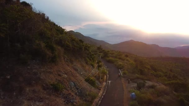 Flygfoto utsikt vid solnedgången på en väg i det bergiga området i Asien. — Stockvideo