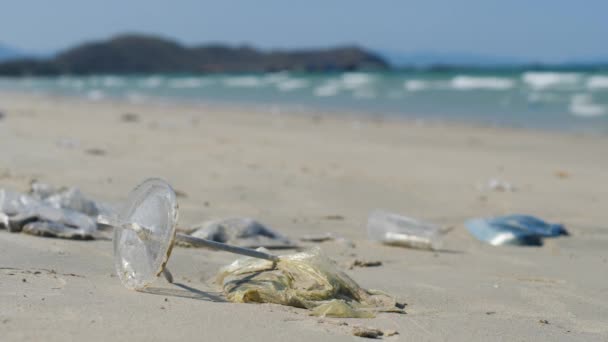 Close-up van plastic zakken, gebruikte rietjes en plastic bekertje op het strand. — Stockvideo