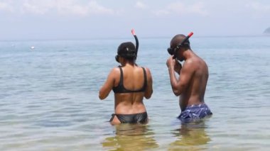 Kadın ve erkek, yaz günü sakin mavi denizde birlikte şnorkelle yüzerler..