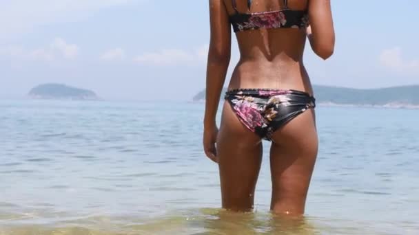 Närbild av asiatiska kvinnors solbrända kropp i bikini stående i vatten vid stranden. — Stockvideo