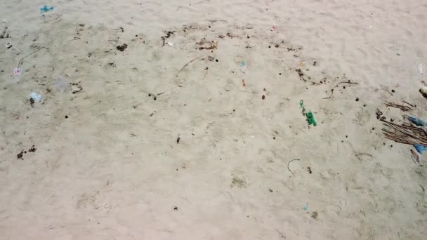 Vista panorámica de arriba abajo de la basura y el plástico en la arena en una playa pública. — Vídeo de stock