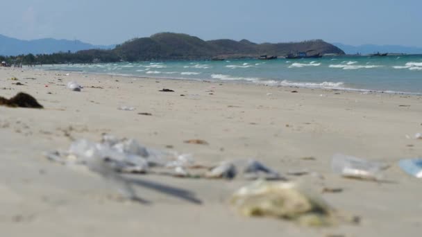 En förorenad turistisk strand i Asien full av skräp och plast på sanden. — Stockvideo