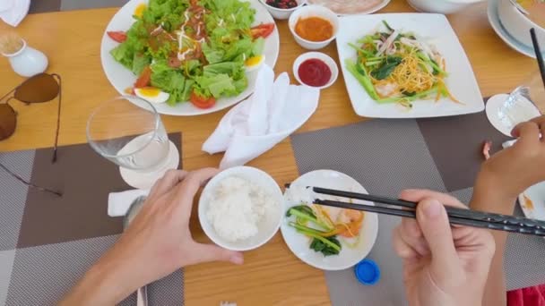 POV: Manos de gente usando palillo en comer comida en la mesa del restaurante. — Vídeo de stock