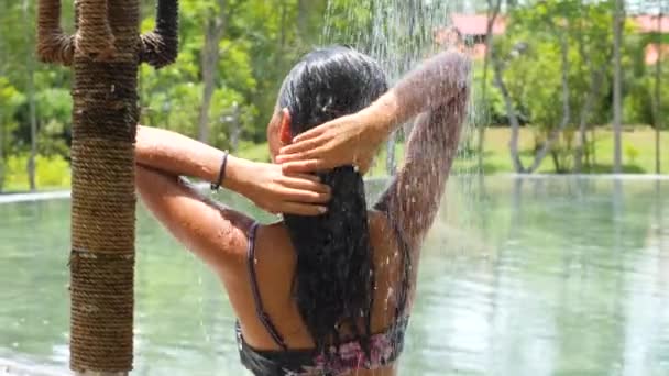 Jovem mulher de biquíni tomando banho ao ar livre em câmera lenta perto da piscina em um dia ensolarado. — Vídeo de Stock