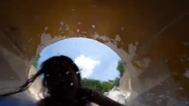 Playful woman filming a selfie video sliding down inside a water slide tunnel. — Stock Video