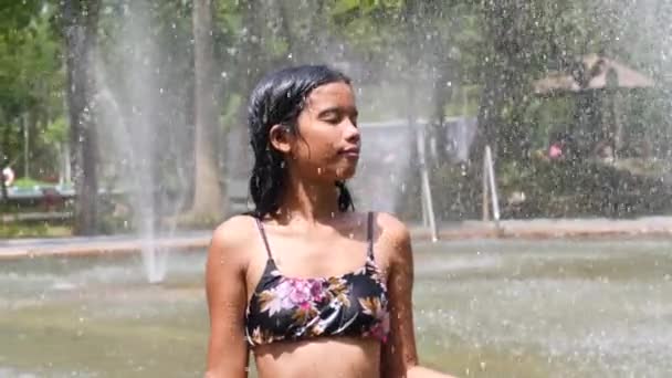 Jovem de pé e relaxante na piscina chuveiro fonte. — Vídeo de Stock