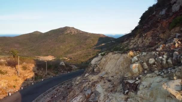 Drone volar sobre carretera de montaña escénica con acantilados rocosos y pintoresco paisaje. — Vídeo de stock