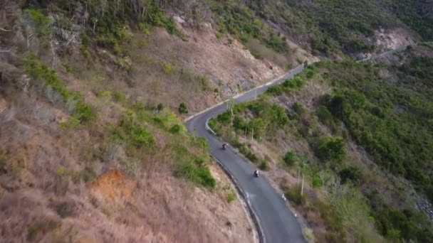 Aerial over motorists traveling at countryside road on the edge of the mountain — Stock Video